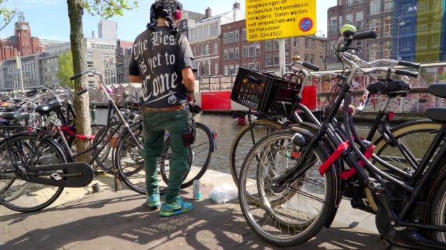 Un-hombre-cuidando-sus-bicicletas-siendo-estacionados