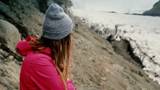 Junge-Brünette-Frau-auf-dem-Berg-stehen-und-blickte-auf-Gletscher-Vatnajökull-Eis-Lagune-in-Island