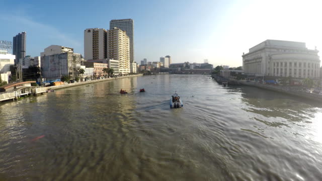 Motorized-boat-sailing-on-huge,-murky-Pasig-River-early-morning