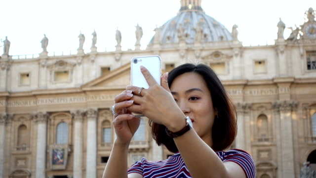 pretty--Chinese-tourist-taking-selfie-in-San-Pietro-Square,-Rome