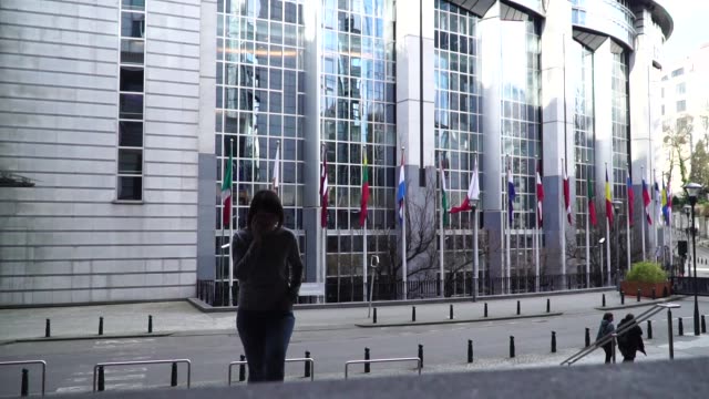 la-señora-es-caminando-y-hablando-por-el-teléfono-cerca-del-Parlamento-Europeo-en-Bruselas.-Bélgica.-cámara-lenta