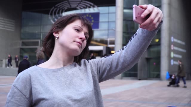Frau-Tourist-nimmt-Pictureson-auf-Smartphone-in-der-Nähe-des-Europäischen-Parlaments-in-Brüssel.-Belgien