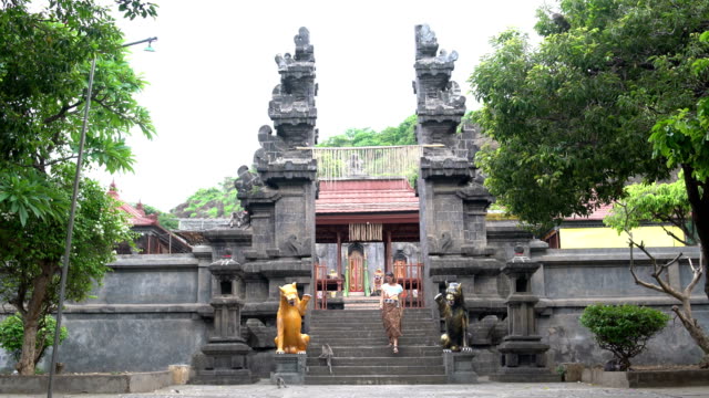 Una-mujer-en-una-falda-larga-desciende-los-escalones-de-un-templo-budista