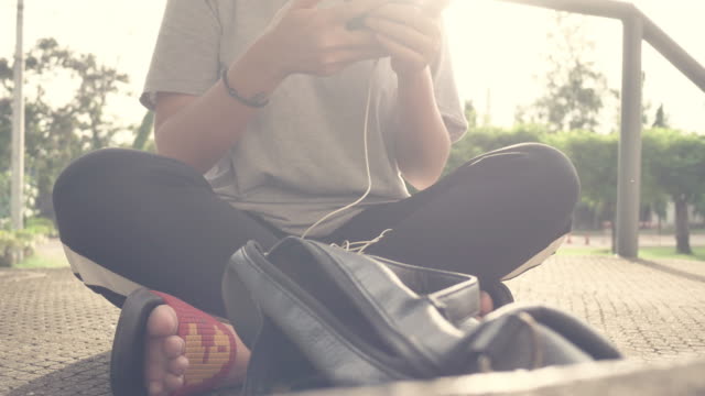 Beautiful-young-asian-woman-listening-to-music-on-a-smart-phone-in-the-city.-Young-asian-woman-relaxing-listening-to-music-on-the-street.