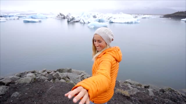 Folgen-Sie-mir-in-Konzept,-junge-Frau-führenden-Freund-zur-Gletscherlagune-Islands
