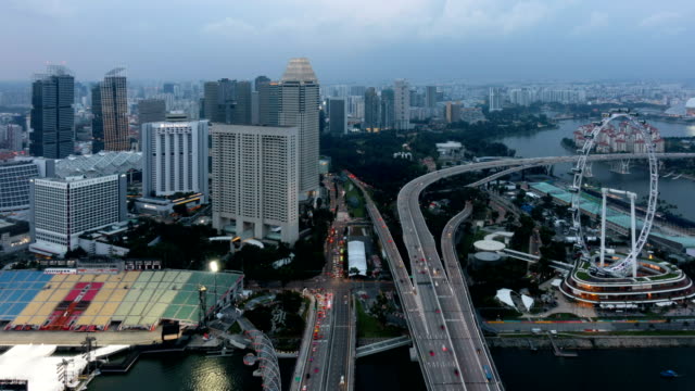 Día-de-lapso-de-tiempo-a-noche-de-Singapore-Flyer,-la-Noria-y-edificios-rascacielos-en-el-distrito-financiero,-centro-de-la-ciudad-de-Singapur