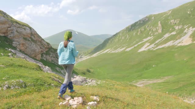 Mujer-caminante-disfrutar-de-hermoso-paisaje-de-montaña-y-hacer-foto-a-teléfono-móvil