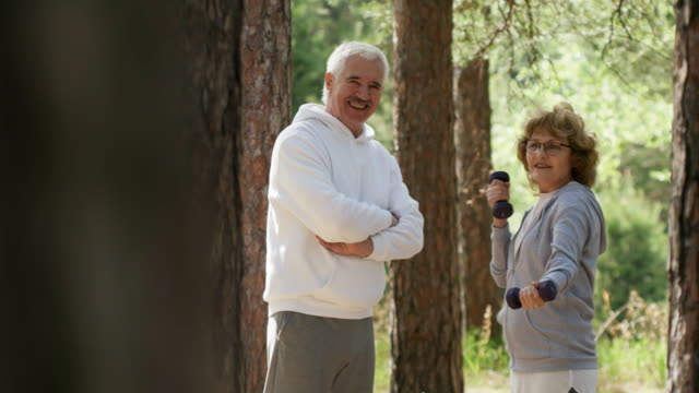 Elderly-Woman-and-Man-Training-in-Park-and-Smiling