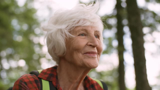 Senior-mujer-caminante-disfrutar-de-vistas-del-bosque