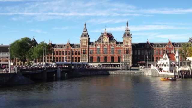 Traditional-boat-at-the-canal-waterfront-in-front-of-Amsterdam-Central-station,-Europe.