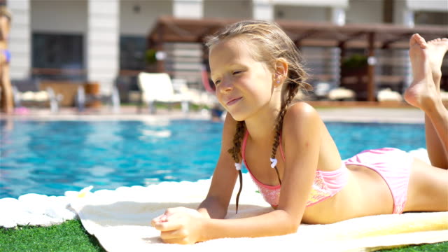 Beautiful-little-girl-having-fun-near-an-outdoor-pool