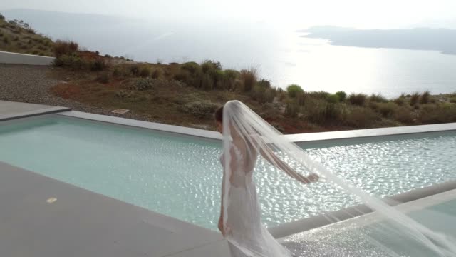Luftaufnahme-der-Frau-mit-Hochzeitskleid-auf-der-Insel-Santorini,-Griechenland.