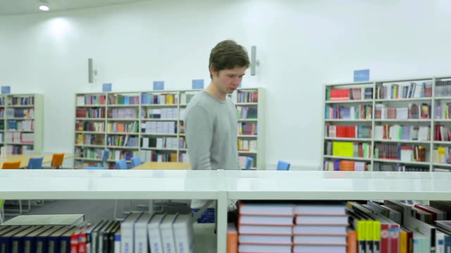 Young-Man-Taking-Book-from-Bookshelf