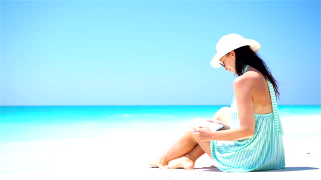 Young-beautiful-woman-enjoying-vacation-on-white-tropical-beach