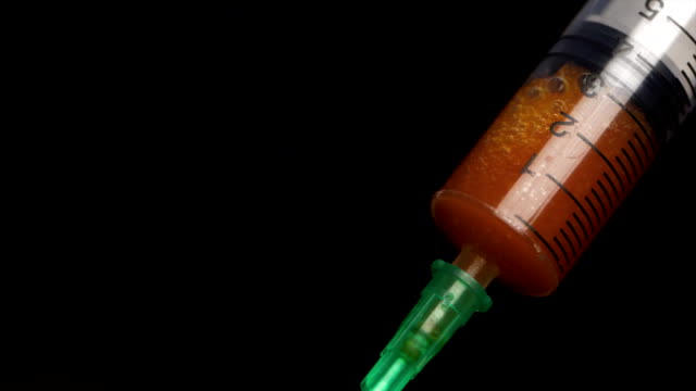Syringe-with-blood-on-a-black-background-close-up.-The-syringe-with-the-medicine-is-close-up-ready-for-injection.-Medical-syringe-filled-with-red-liquid