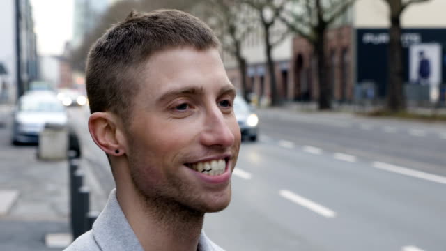 Kopf-geschossen-Porträt-eines-jungen-Mannes-lächelnd-auf-Stadtstraße
