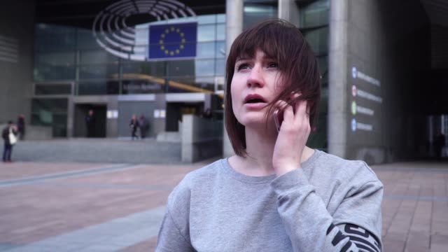 Dame-ist-Fuß-und-am-Telefon-in-der-Nähe-des-Europäischen-Parlaments-in-Brüssel.-Belgien.-Slow-motion