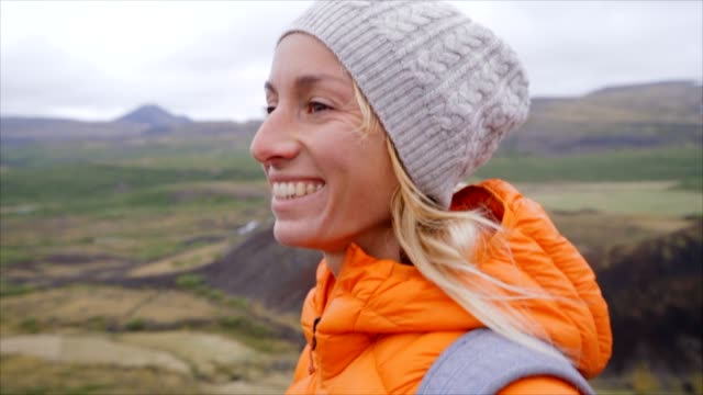 Slow-motion-video-of-young-woman-hiking-in-Iceland-on-top-of-volcanic-crater,-happiness-in-nature,-caucasian-female-smiling-and-enjoying-life.-People-discovery-concept