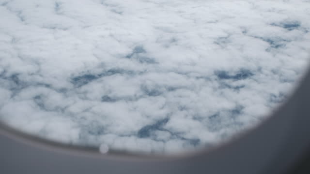El-cielo-azul-en-un-día-nublado-a-través-de-una-ventana-de-avión