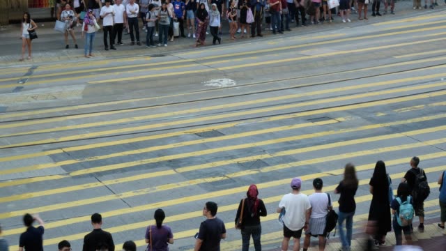 Menge-von-Menschen-zu-Fuß-überqueren-Straße-an-einer-belebten-Kreuzung-in-Hong-Kong,