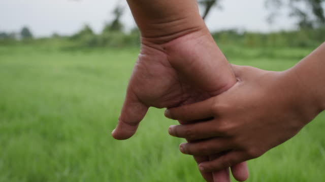 Close-up-hand-of-the-father-holding-the-daughter-hand-in-slow-motion-scene