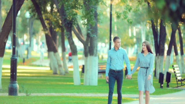 Joven-pareja-feliz-caminando-en-el-parque-de-verano-hermoso