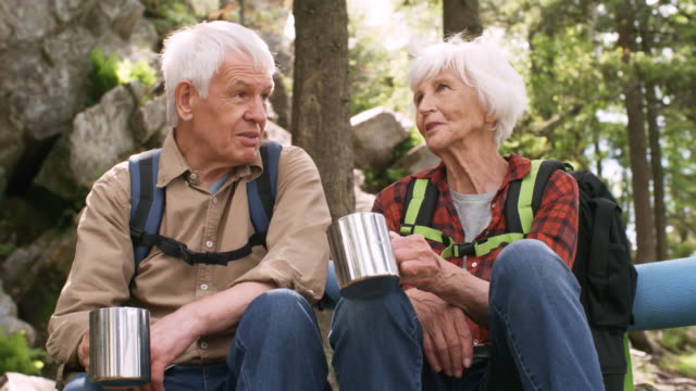 Las-personas-mayores-bebiendo-té-y-hablando-en-el-bosque-de-la-montaña