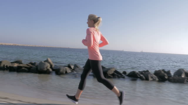 mujer-para-correr-a-lo-largo-de-la-costa-del-mar
