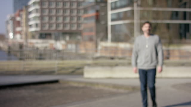 Middle-aged-man-walking-into-focus-in-urban-city