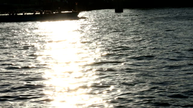 Barco-con-los-turistas-pasa-a-través-de-la-tira-de-luz-sobre-el-agua