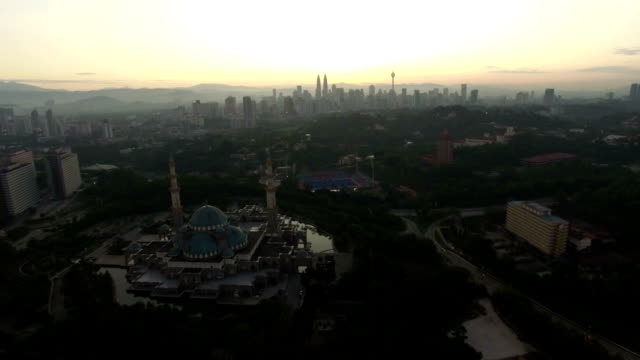Luftbild-von-Sonnenaufgang-im-Federal-Moschee-Kuala-Lumpur-mit-Blick-auf-die-Skyline-der-Stadt-im-Hintergrund.
