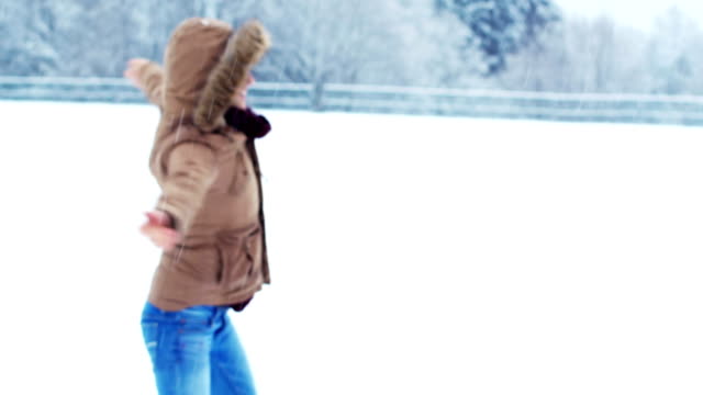Smiling-woman-in-fur-jacket-enjoying-the-snowfall
