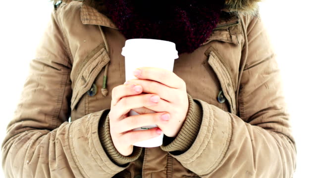 Smiling-woman-in-fur-jacket-having-coffee-during-snowfall