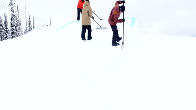 Gruppe-von-Mann-Reinigung-Schnee-im-Skigebiet