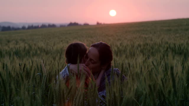 young-Asian-family-in-a-field-with-a-baby-1-year-on-hand,-the-concept-of-family-happiness,-beautiful-sunlight,-sunset,-slow-motion