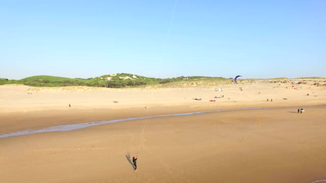 Personas-kitesurf-en-popular-bandera-azul-playa-de-Guincho.