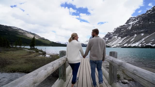 Young-couple-enjoying-nature-at-mountain-lake,-Canada