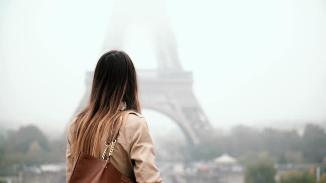 Junge-schöne-Frau-zu-Fuß-in-der-Innenstadt-und-am-Handy-sprechen.-Weibchen-in-der-Nähe-des-Eiffelturms-in-Paris,-Frankreich