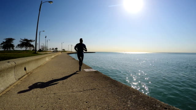 Fit-African-American-male-running-along-Chicago-shoreline