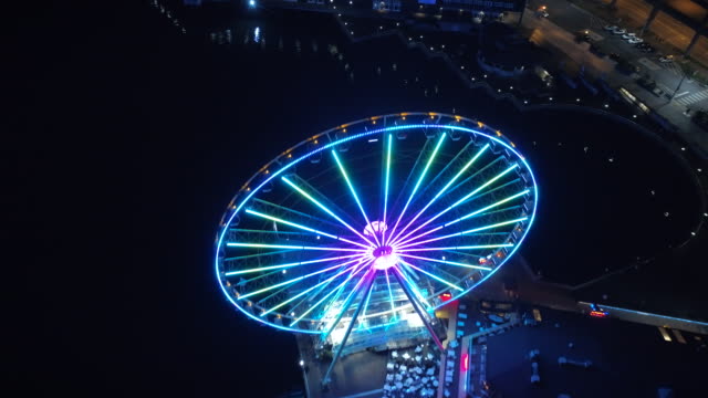 Helicopter-View-Passing-Over-Bright-Ferris-Wheel-at-Night