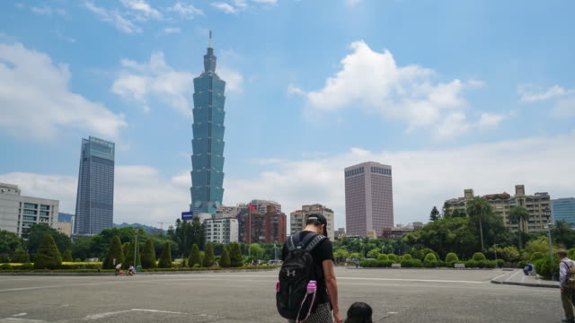 Taipeh,-Taiwan---25.-April-2018:-Zeitraffer-von-unbekannten-Touristen-gehen-auf-Dr.-Sun-Yat-Sen-Memorial-Park-mit-Taipei-101-Gebäude-im-Hintergrund.