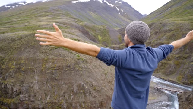 Young-man-on-top-of-canyon-arms-outstretched-for-happiness
