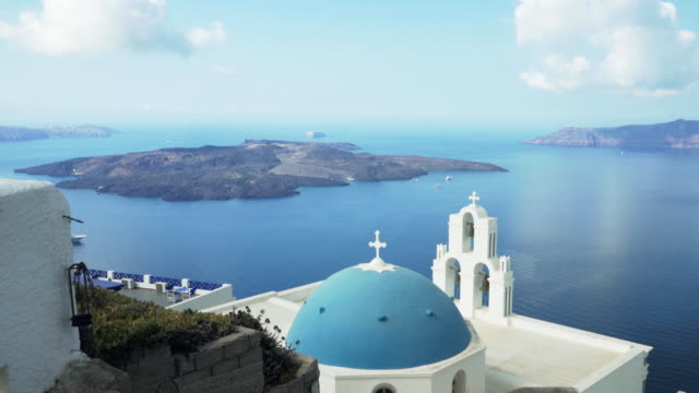 wide-view-of-three-bells,-a-blue-dome-and-the-volcano-at-fira,-santorini