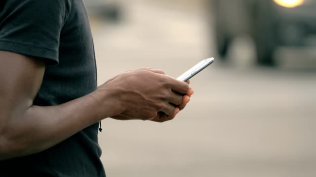 Hand-des-jungen-schwarzen-Kerl-Tippen-auf-smartphone