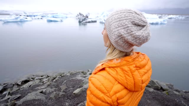 Junge-Frau-Betrachtung-Gletschersee-in-Island-genießen-Sie-die-Natur-und-die-Schönheit-der-Eisberge