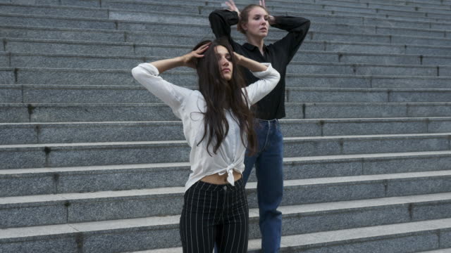 Zwei-junge-Frau-auf-Außentreppe-eines-Gebäudes-in-verschiedenen-Tanz-Posen