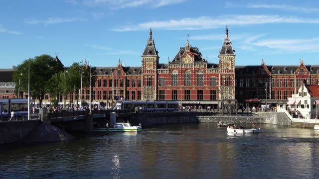 Centro-de-Amsterdam.-Tranvías-y-barcos-frente-a-la-estación-Central-de-Ámsterdam,-Europa.