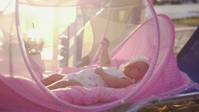 Baby-in-pink-bassinet-outdoor-in-summer