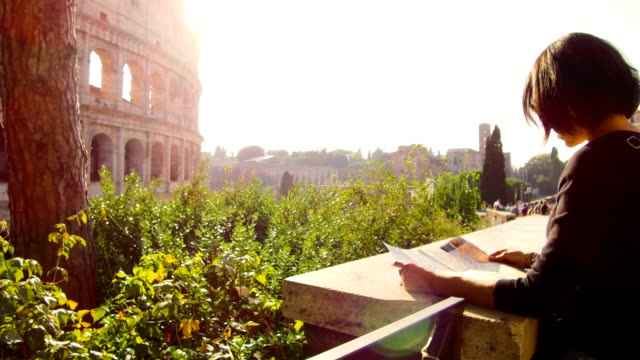 woman-looks-at-tourist-map-in-front-of-the-majestic-Colosseum-in-Rome