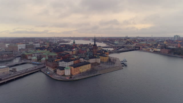 Volando-sobre-la-ciudad-de-Estocolmo.-Vista-aérea-del-casco-antiguo-y-Riddarholmen-horizonte-de-paisaje-urbano.-Tiro-de-Drone-volando-hacia-los-edificios-históricos-en-una-isla-en-el-centro-de-Estocolmo,-Suecia